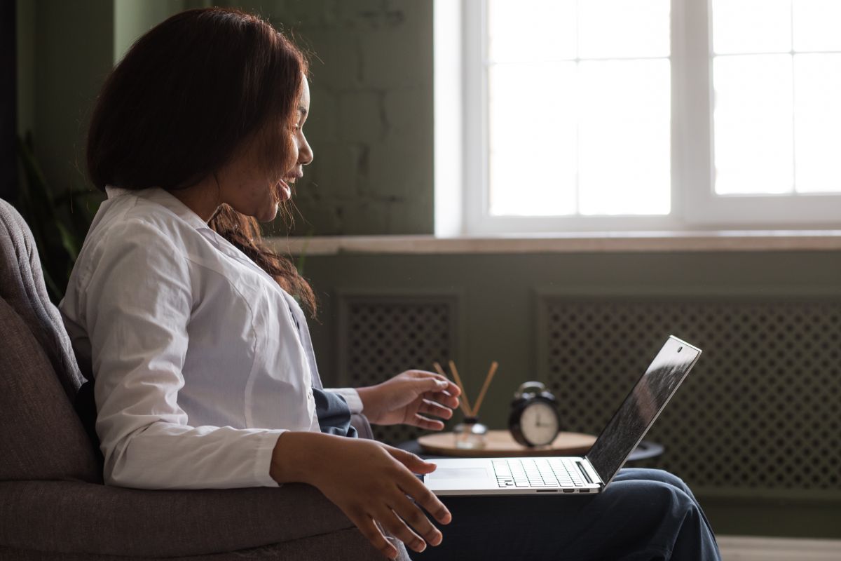 A woman participating in telehealth therapy on her laptop.