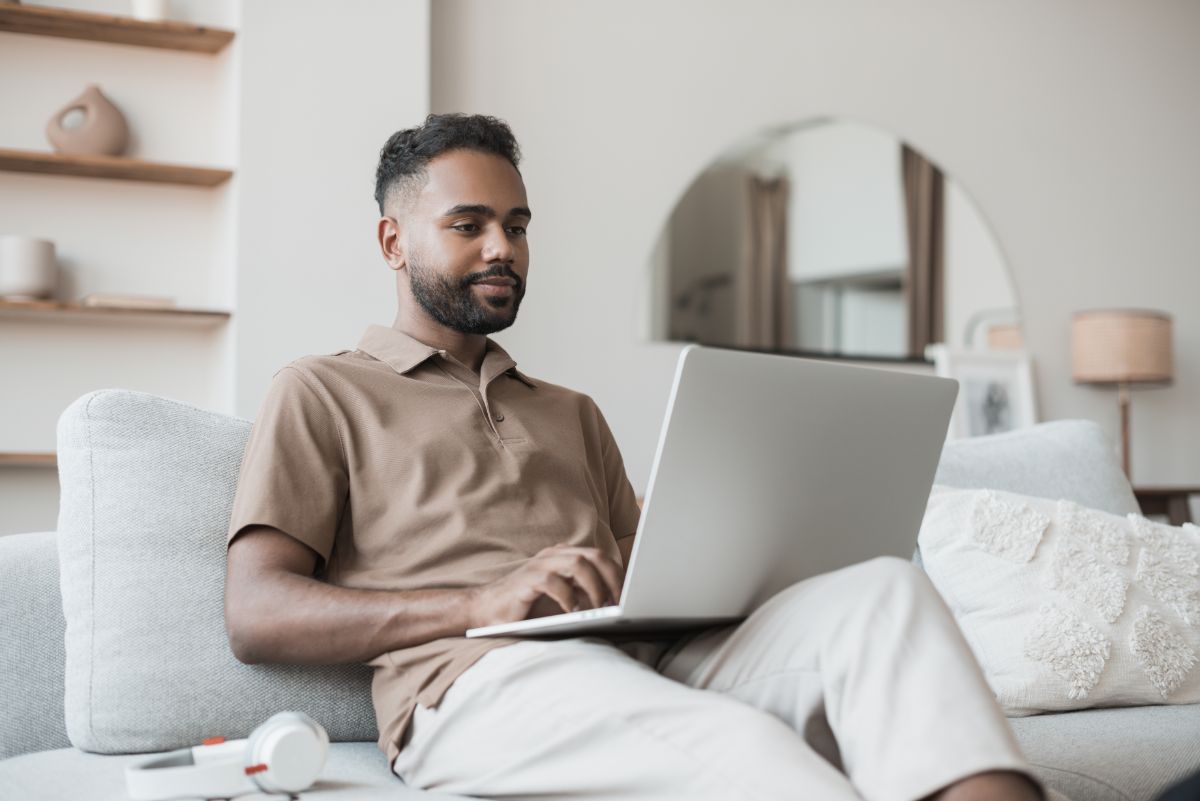 A man attending is telehealth therapy appointment on his laptop.